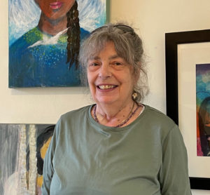 woman with grey hair and green blouse smiling at camera